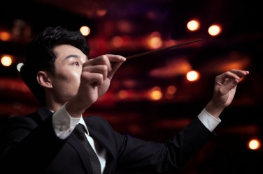An orchestra conductor during a performance. An orchestra conductor during a performance.