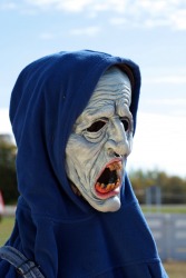 A person wearing a grotesque mask. A person wearing a grotesque mask.