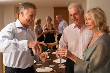 A couple recieve a drink from their host. A couple recieve a drink from their host.