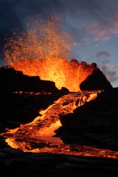 Molten lava streams down the side of a volcano. Molten lava streams down the side of a volcano.