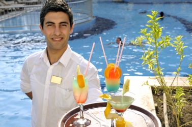 A server brings a tray of drinks. A server brings a tray of drinks.