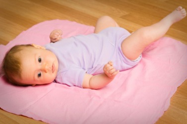 A baby laying on a pink blanket. A baby laying on a pink blanket.