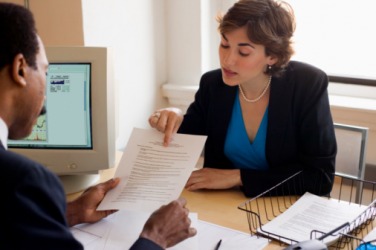 A manager discussing an employee's accomplishments during a performance assessment. A manager discussing an employee's accomplishments during a performance assessment.