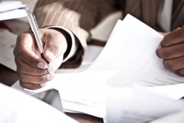 The man signs the documents in a perfunctory manner because he has done this task many times. The man signs the documents in a perfunctory manner because he has done this task many times.