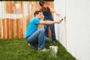 The pernickety woman instructs her husband on the right way to paint a fence. The pernickety woman instructs her husband on the right way to paint a fence.