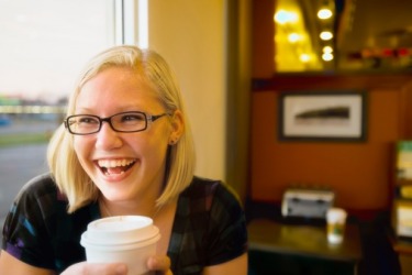 A young lady getting a pick me up from a cup of coffee. A young lady getting a pick me up from a cup of coffee.