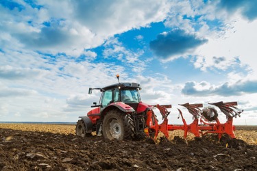 A tractor plowing a field. A tractor plowing a field.