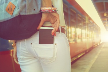 A woman putting a phone in the back pocket of her pants. A woman putting a phone in the back pocket of her pants.