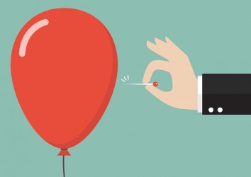 A balloon getting popped by a pin. A balloon getting popped by a pin.