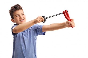 A boy shooting with a slingshot A boy shooting with a slingshot