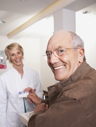A patient handing over his insurance card. A patient handing over his insurance card.