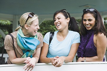 A trio of women laughing and talking. A trio of women laughing and talking.