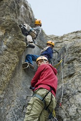 A family climbing a steep cliff. A family climbing a steep cliff.