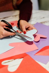 Cutting construction paper hearts with precision using scissors. Cutting construction paper hearts with precision using scissors.