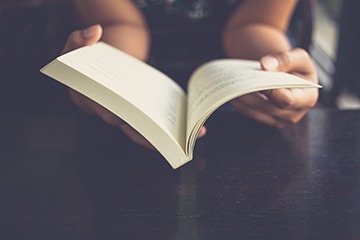 A person reading the preface of a book. A person reading the preface of a book.