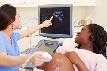 Pregnant woman having an ultrasound scan. Pregnant woman having an ultrasound scan.