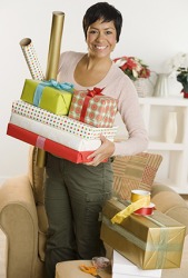 A woman holding several presents and gift wrap. A woman holding several presents and gift wrap.