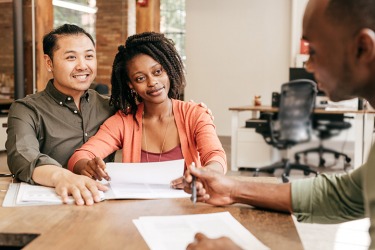 A loan processer working with a couple. A loan processer working with a couple.