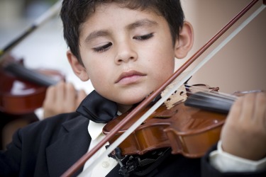 A child musical prodigy playing the violin. A child musical prodigy playing the violin.