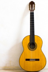 The guitar is propped against the wall. The guitar is propped against the wall.