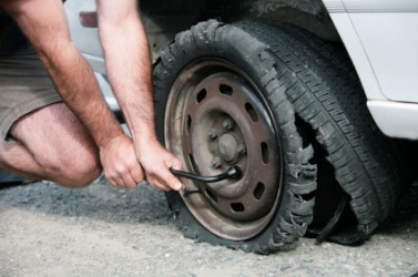 A man changing a tire after a blowout. A man changing a tire after a blowout.