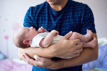 A proud father holding his newborn son. A proud father holding his newborn son.