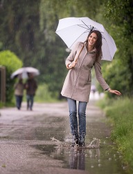 A woman walking in a puddle on a rainy day. A woman walking in a puddle on a rainy day.