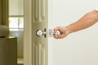 He pulls the door open to enter the room. He pulls the door open to enter the room.