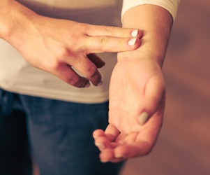 A man taking his pulse on his wrist. A man taking his pulse on his wrist.