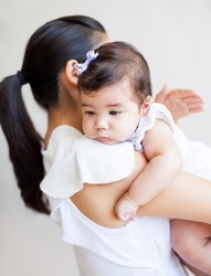 A mom gently pats her baby's back. A mom gently pats her baby's back.