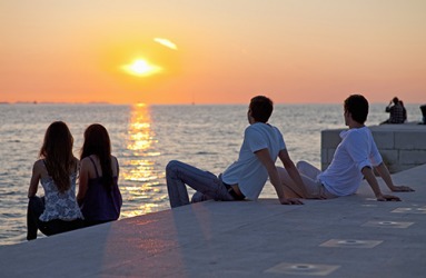 Crowds of people gather at the pier every evening to watch the remarkable sunsets. Crowds of people gather at the pier every evening to watch the remarkable sunsets.