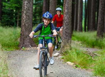 Zach and his sister ride their bicycles on the nature trail. Zach and his sister ride their bicycles on the nature trail.
