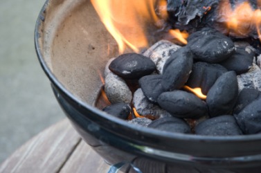 A grill filled with burning briquettes. A grill filled with burning briquettes.