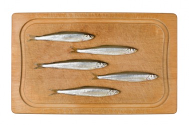 Some brislings or sprats on a cutting board. Some brislings or sprats on a cutting board.