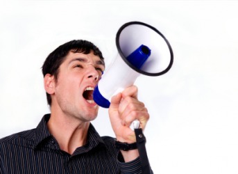 A man speaking through a bullhorn. A man speaking through a bullhorn.