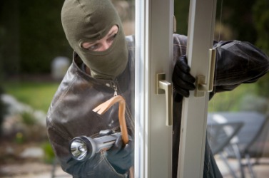 A burglar breaking into a house. A burglar breaking into a house.