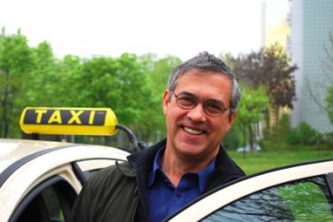 A cabdriver getting in to his cab or taxi. A cabdriver getting in to his cab or taxi.