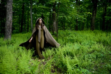 A woman wearing a cape. A woman wearing a cape.