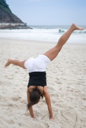 A woman doing a cartwheel at the beach. A woman doing a cartwheel at the beach.