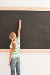 A girl writing on a chalkboard. A girl writing on a chalkboard.