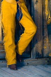 A man wearing chaps. A man wearing chaps.