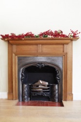 A mantelpiece, or chimney piece, decorated with sprigs of berries. A mantelpiece, or chimney piece, decorated with sprigs of berries.