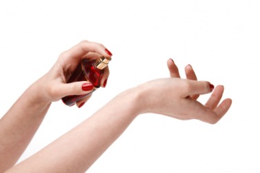 A woman applying cologne. A woman applying cologne.