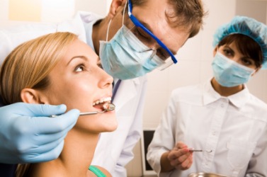 A woman having her teeth examined by her dentist. A woman having her teeth examined by her dentist.