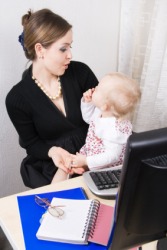 A baby distracts her mother from her work. A baby distracts her mother from her work.