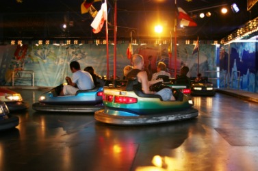 People riding dodgem cars. People riding dodgem cars.
