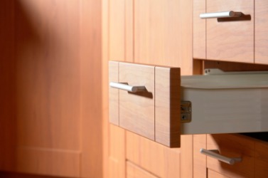An open drawer in a kitchen. An open drawer in a kitchen.