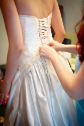 A bride being assisted by her dresser. A bride being assisted by her dresser.