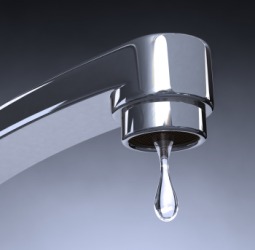 Water about to drip from a faucet. Water about to drip from a faucet.