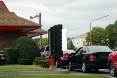 Cars lined up at the drive-through at a fast food restaurant. Cars lined up at the drive-through at a fast food restaurant.